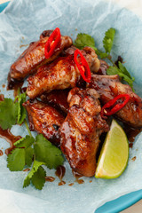 Close up of jamaican style glazed chicken wings with chili pepper and teriyaki sauce