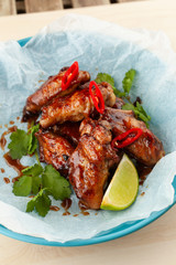 Close up of jamaican style glazed chicken wings with chili pepper and teriyaki sauce