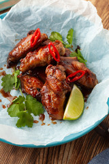 Close up of jamaican style glazed chicken wings with chili pepper and teriyaki sauce