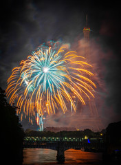 France celebrating Independence day Bastille day in Paris near Eiffel tower with fireworks. Seine river, pont du bir-hakeim, and railway captured in one frame with the Eiffel tower and the fireworks.