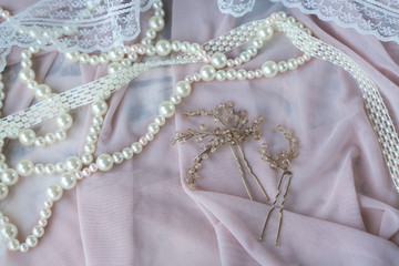 Wedding background with pearls and hair accessories on pink background