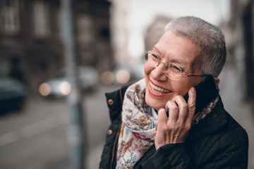 Old lady enjoying a nice talk on her phone in the streets