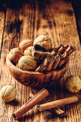 Cinnamon sticks and dried limes in wooden bowl