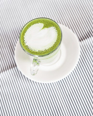 Green matcha latte on background. Healthy drink.