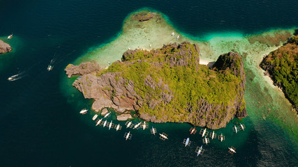 Tourist boats over tropical lagoon and coral reef. El nido, Philippines, Palawan. tropical landscape bay with beach and clear blue water surrounded by cliffs