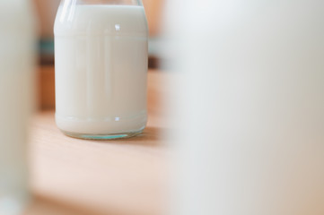 Closeup fresh milk bottles on wooden box near the window. A healthy drink concept. Copy space wallpaper.