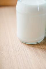 Closeup fresh milk bottles on wooden box near the window. A healthy drink concept. Copy space wallpaper.