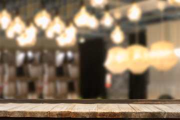 Selective focus of wooden table in front of decorative indoor string lights. Christmas, festival and holiday concepts, can used for display or montage your product