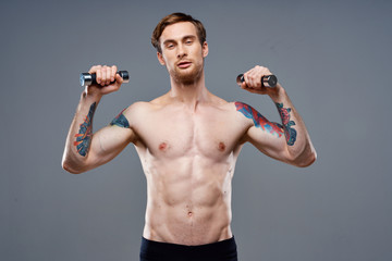 young man doing exercises with dumbbells