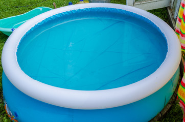 Obraz na płótnie Canvas blue round inflatable pool on green grass