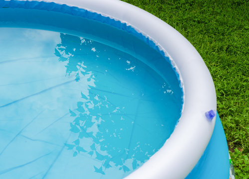 blue inflatable pool on green grass