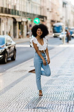 Happy ethnic woman in trendy outfit and looking at camera on summer day