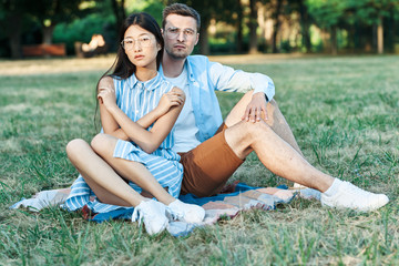 young couple sitting on a bench in park