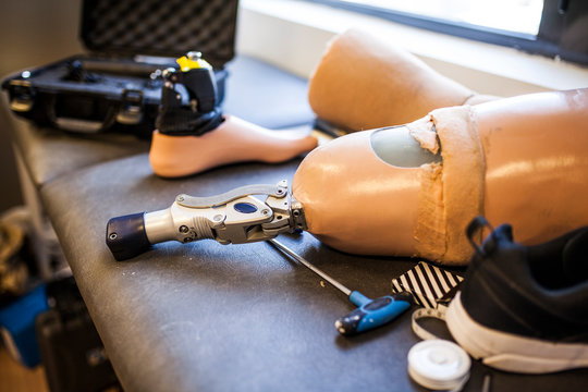 Unrecognizable prosthetic engineer reviewing the prosthesis of a patient and improving the material in his workshop
