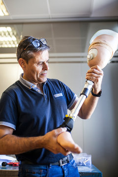 Prosthetic engineer reviewing the prosthesis of a patient and improving the material in his workshop