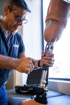 Prosthetic engineer reviewing the prosthesis of a patient and improving the material in his workshop