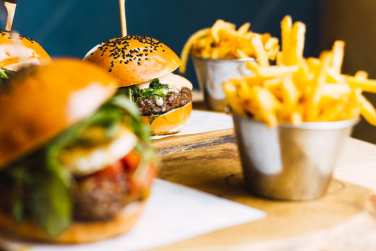 Juicy delicious burger and fried potato on table