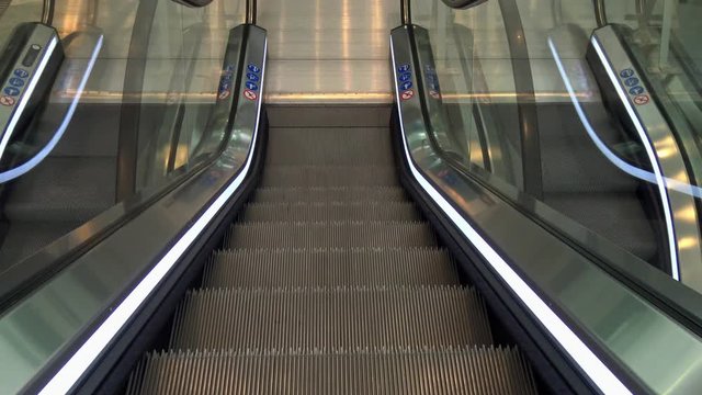 An escalator going down and arriving at the bottom.