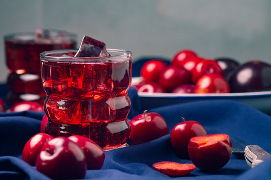 Red beverage near fresh fruits on cloth