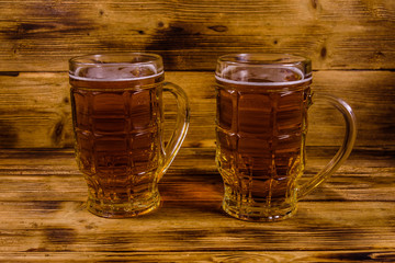 Two glasses of beer on wooden table