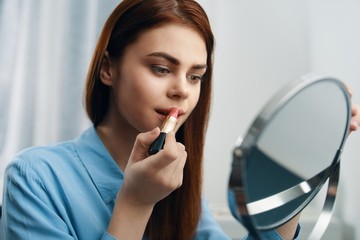 portrait of young woman applying make up