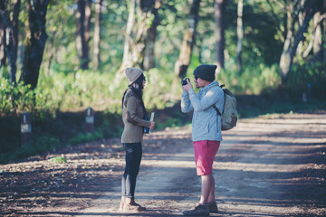 Obraz premium Friends taking pictures of rural hiking trails, young people traveling in the countryside