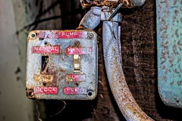 Old Red Labels on Switches in Crumbling Rusted Cannery Industrial Building