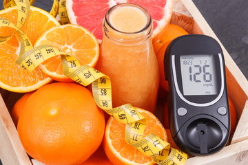 Glucometer, freshly blended coctail or smoothie made of citrus and centimeter. Diabetes, healthy...
