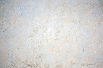 The natural texture of the stucco white wall of the house. Real cracks and damage from time and weather conditions.