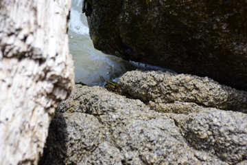 The sand and the waves hit the rocks at the beach of the island.