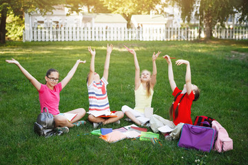 Naklejka premium Four children sitting on the green grass.