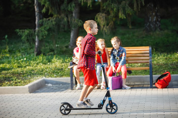 Teen Child riding a scooter in a city park.