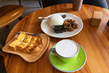 Rice topped with stir-fried pork and basil and Honey toast with milk