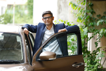 Young indian man with his car