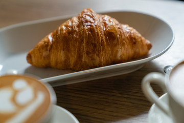 french croissants on plate and cup of espresso coffee on concrete background, top view