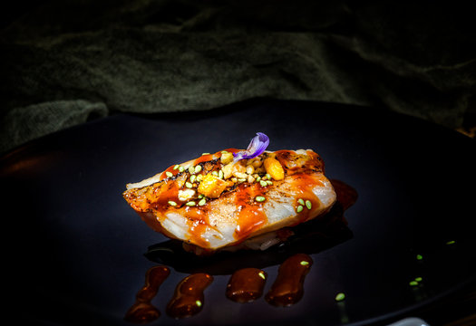 Appetizing delicious colorful sushi with red sauce and green seeds sushi served at table in restaurant