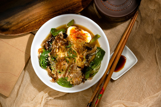 From above appetizing aromatic fresh noodles with egg seeds herbs and sauce served om table in restaurant