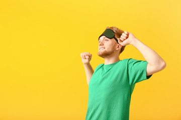 Naklejka premium Sleepy man with mask on color background