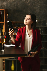 Young female sommelier working in wine cellar