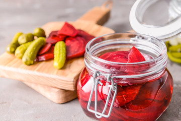 Jar with canned beetroot on grey background