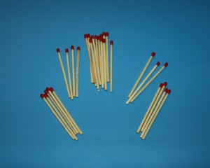 pile of wooden matches with a red tip head lie on a blue background