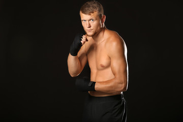 Fototapeta na wymiar Strong male boxer on dark background