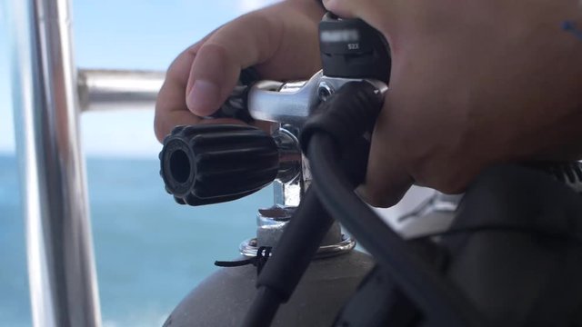 Scuba Diver attaches Regulator Set on Oxygen Tank - On a Dive Boat