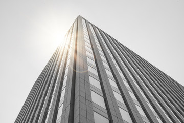 Obraz premium Uprisen angle view outside of buildings with sunlight in the background.