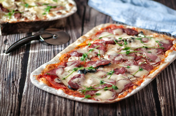 Pizza with cheese and salami. on a wooden table
