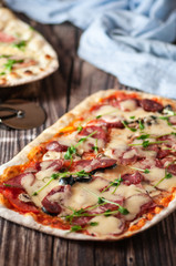 Pizza with cheese and salami. on a wooden table