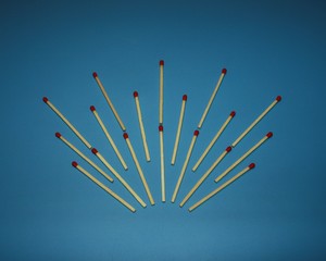 Wooden matches on a blue background laid out