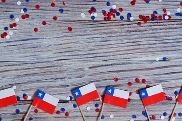 September 18, happy independence day of Chile. memorial day for independence. the concept of patriotism. mini flags with confetti on white wooden background