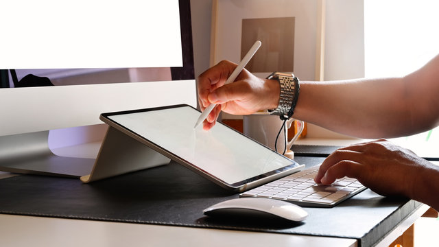 Cropped shot of young designer drawing sketches on graphic tablet in studio