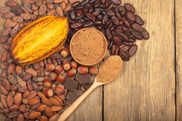 cacao pods, carob pods and dried fruits on wooden background